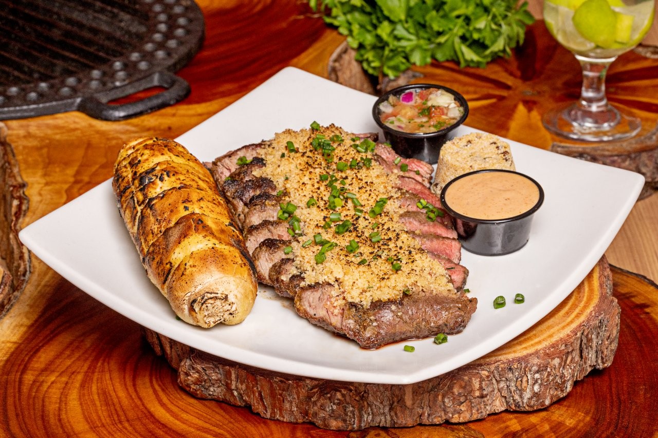Carne grelhada servida com acompanhamentos
